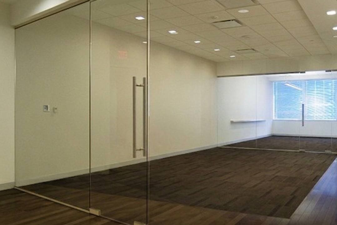 Frameless interior glass door and partition in a commercial interior